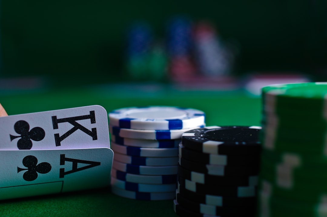 Close-up of playing cards and poker chips on a green felt surface.